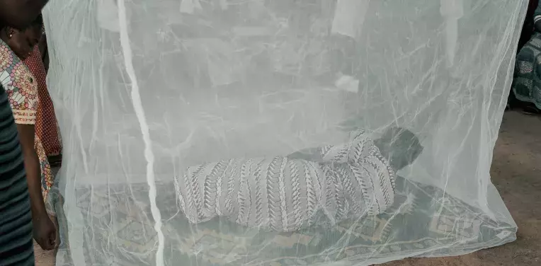  a group of women, from a village a few kilometers from Ouagadougou, as they attend a demonstration lesson on the use of mosquito nets against malaria.