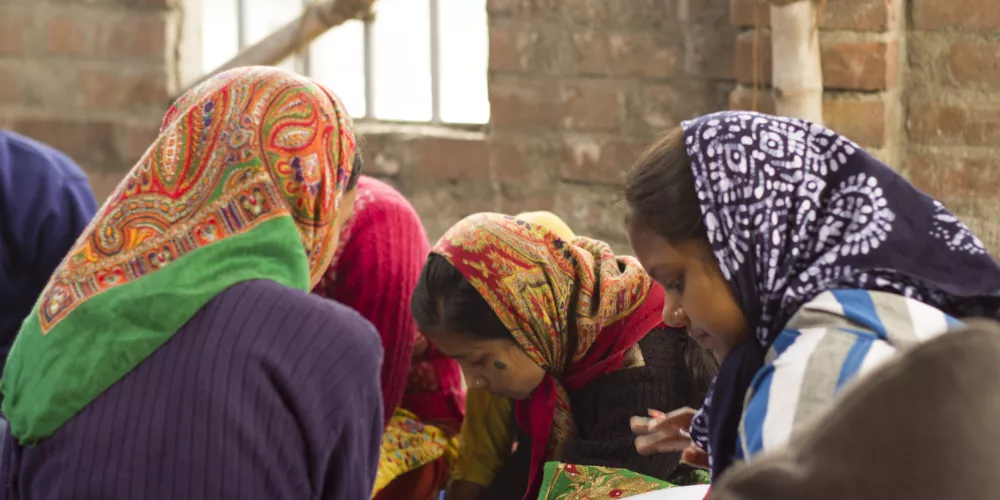 Girls in Indian village school study in a circle, wearing head scarves stock photo