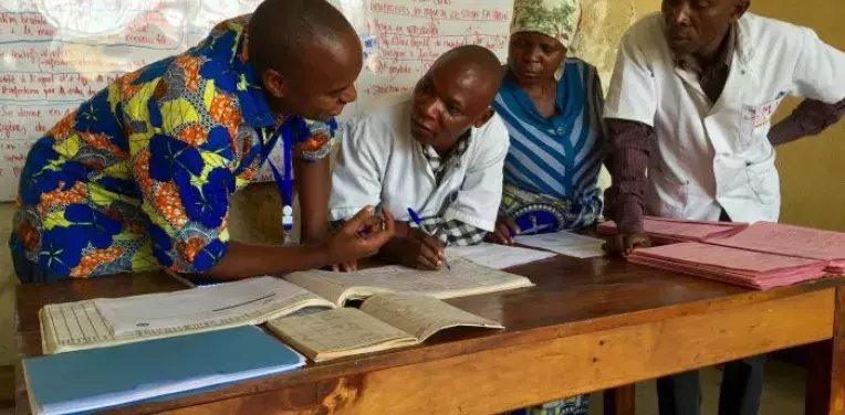 Captured in the Democratic Republic of Congo (DRC), this image depicted a Centers for Disease Control and Prevention (CDC) public health worker on the left, in the process of training local healthcare workers in routine maternal, and newborn health surveillance methods.